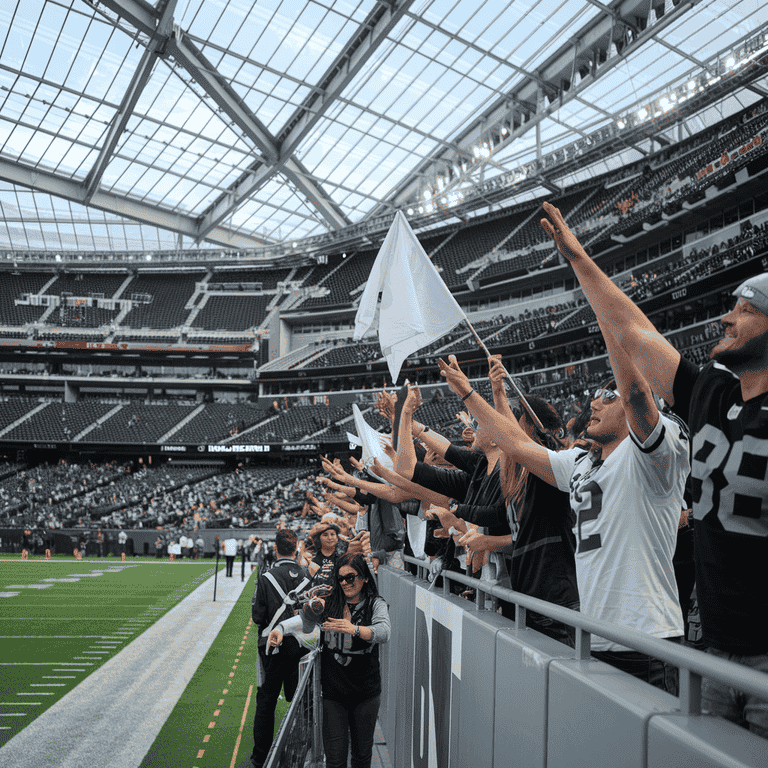 Excited fans cheering during a Las Vegas Raiders game at Allegiant Stadium.