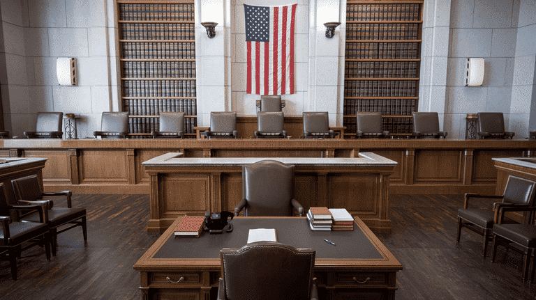 Empty courtroom with a judge’s bench, legal books, and an American flag, symbolizing the criminal process for DUI offenses.