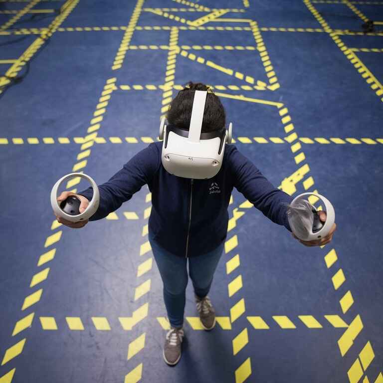 A VR user safely playing in a designated, obstacle-free area with safety markings to prevent accidents.