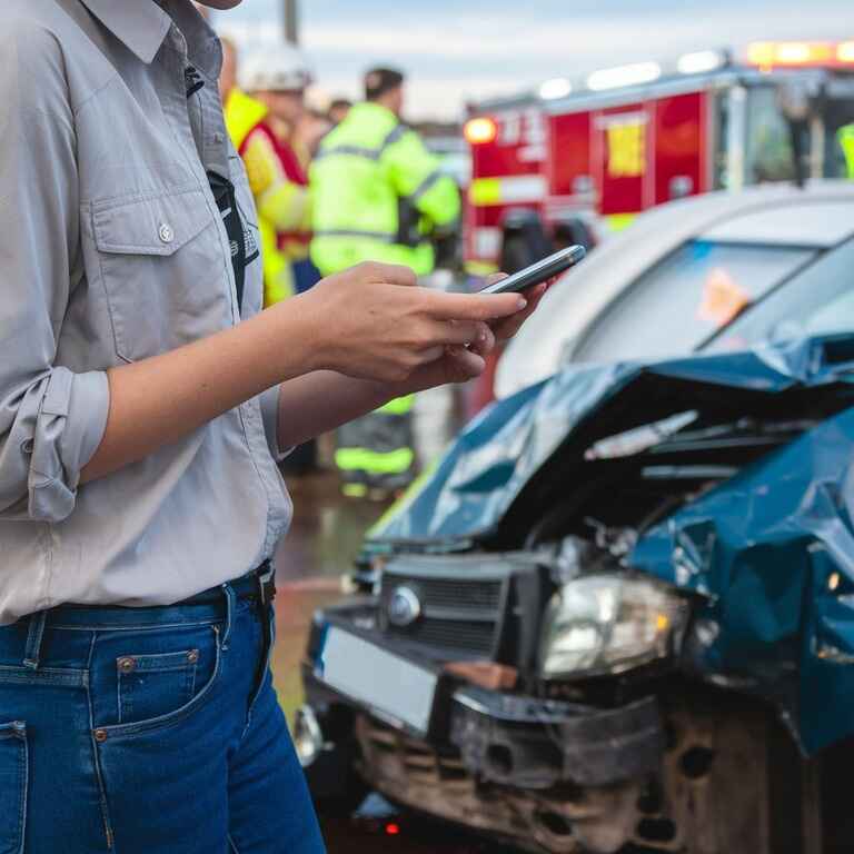 Person checking phone for emergency contact info at an accident scene